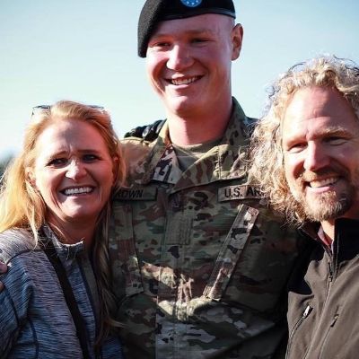Christine is standing on the right, Kody on the left and Paedon in the middle in a military uniform